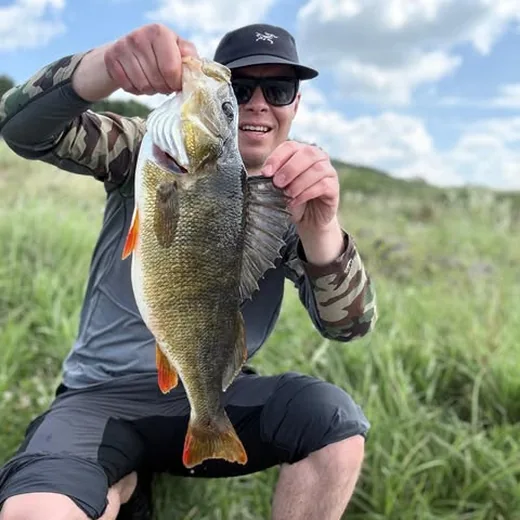 Stefan Koch mit Schwarzbarsch am Wasser